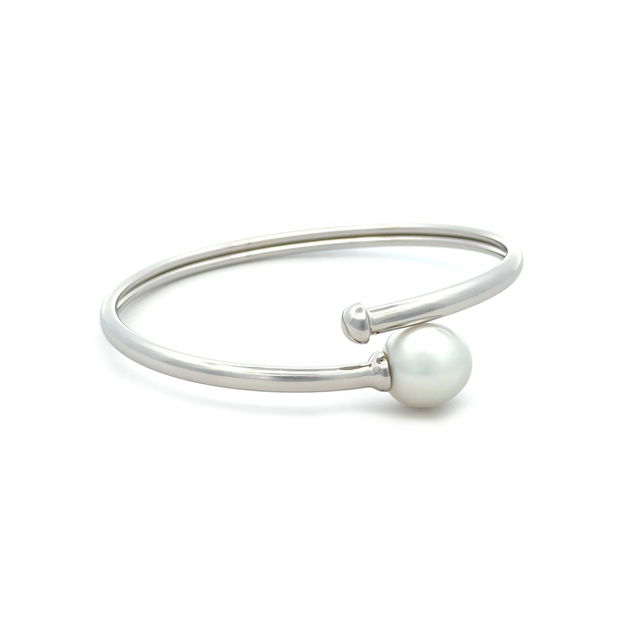 Silver bangle with a white pearl on a white background