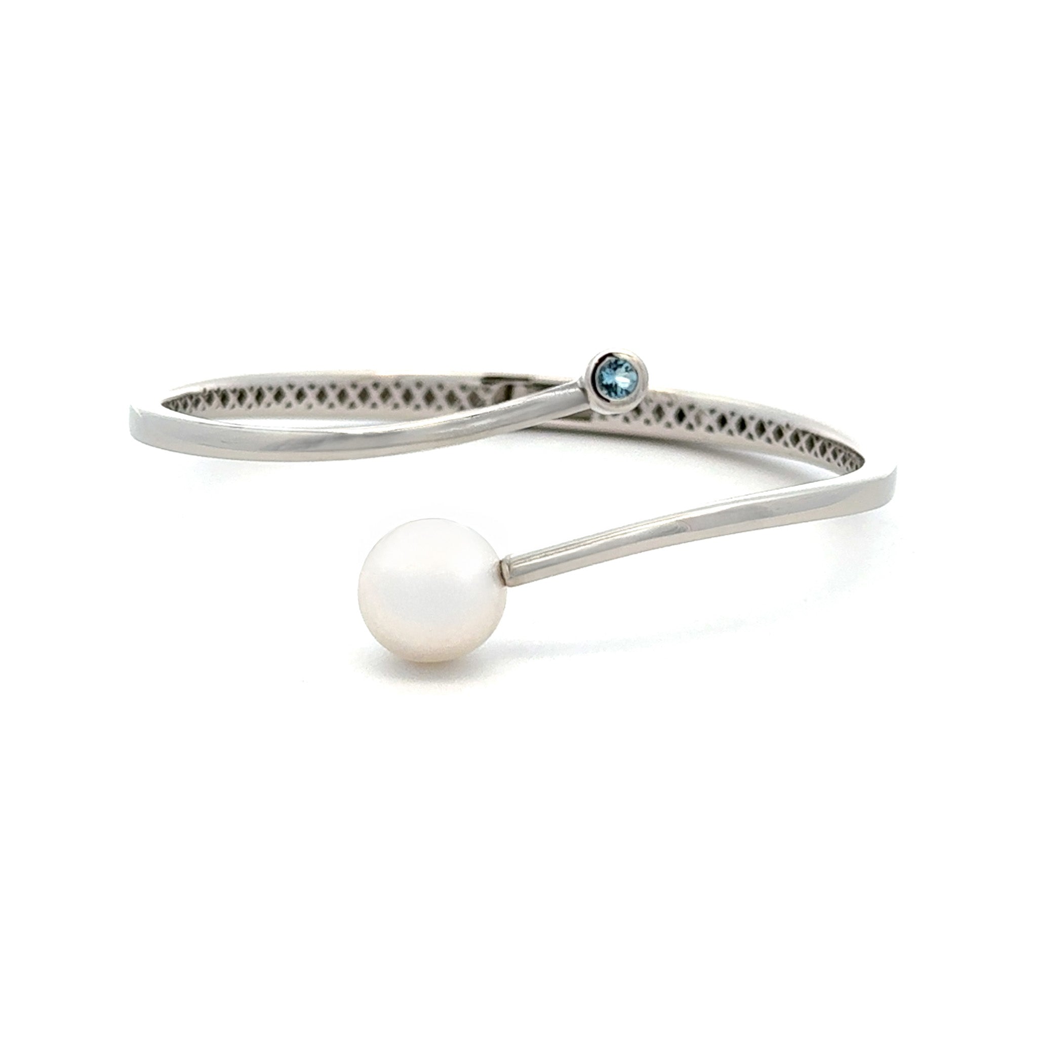 Silver bracelet with a pearl and blue gemstone on a white background