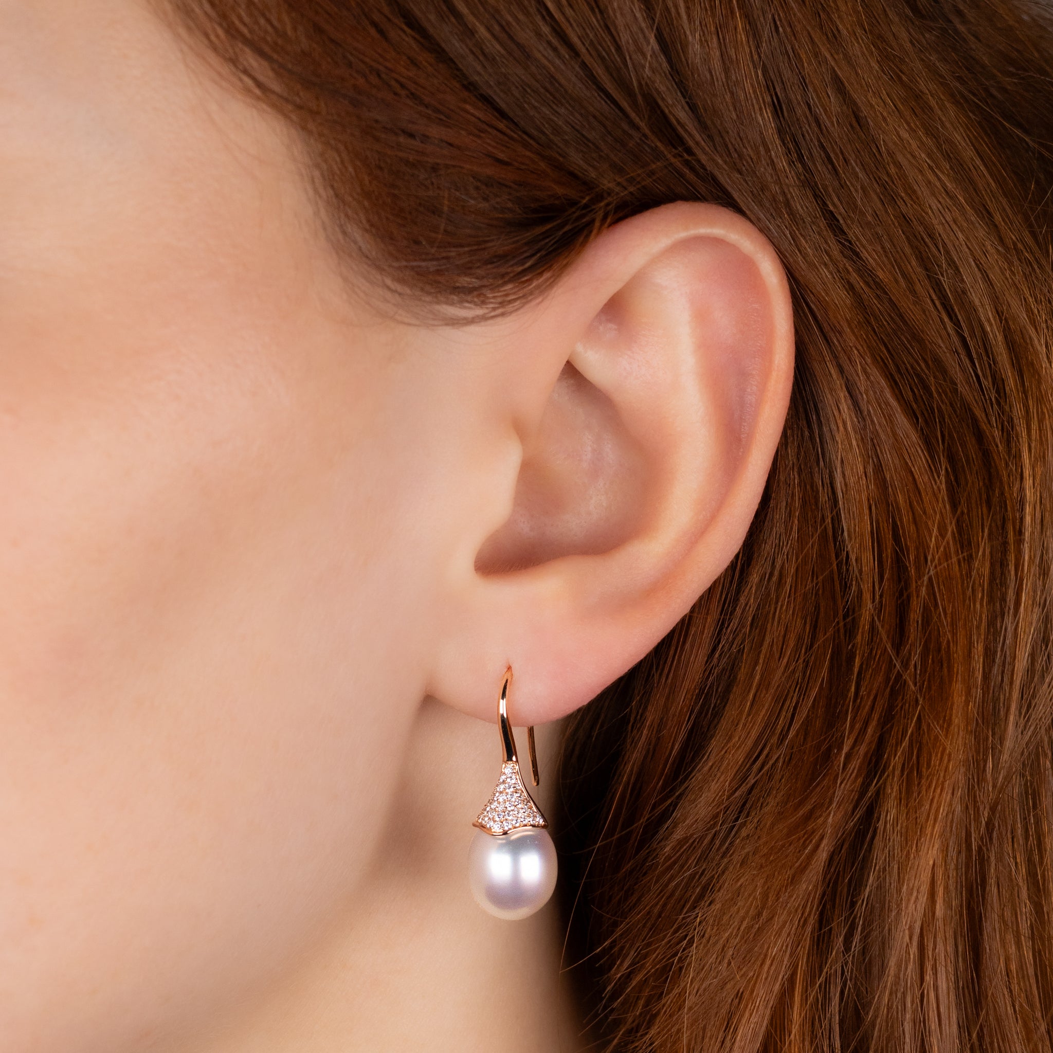 Pearl earring worn by a person with brown hair