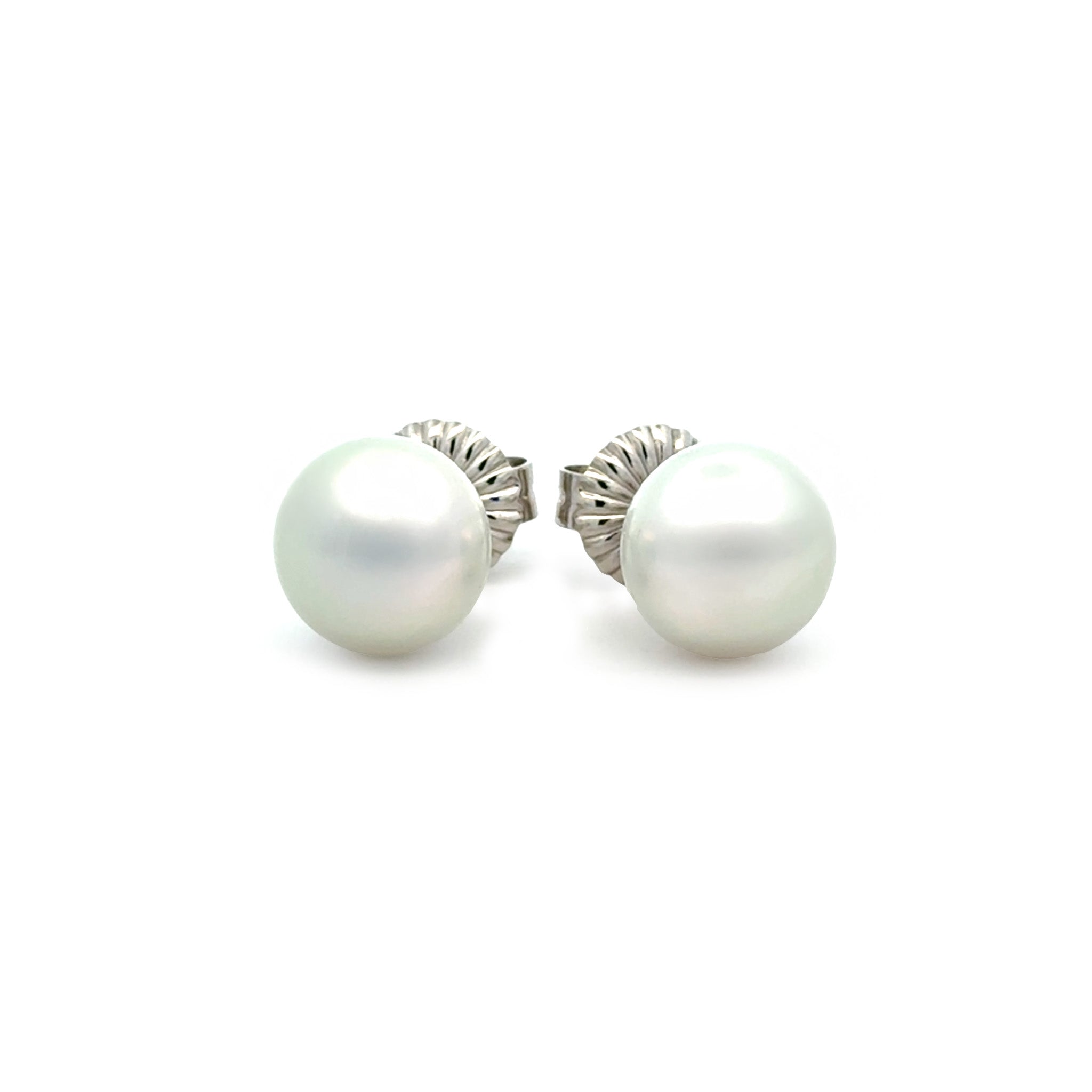 Pair of pearl earrings with silver settings on a white background