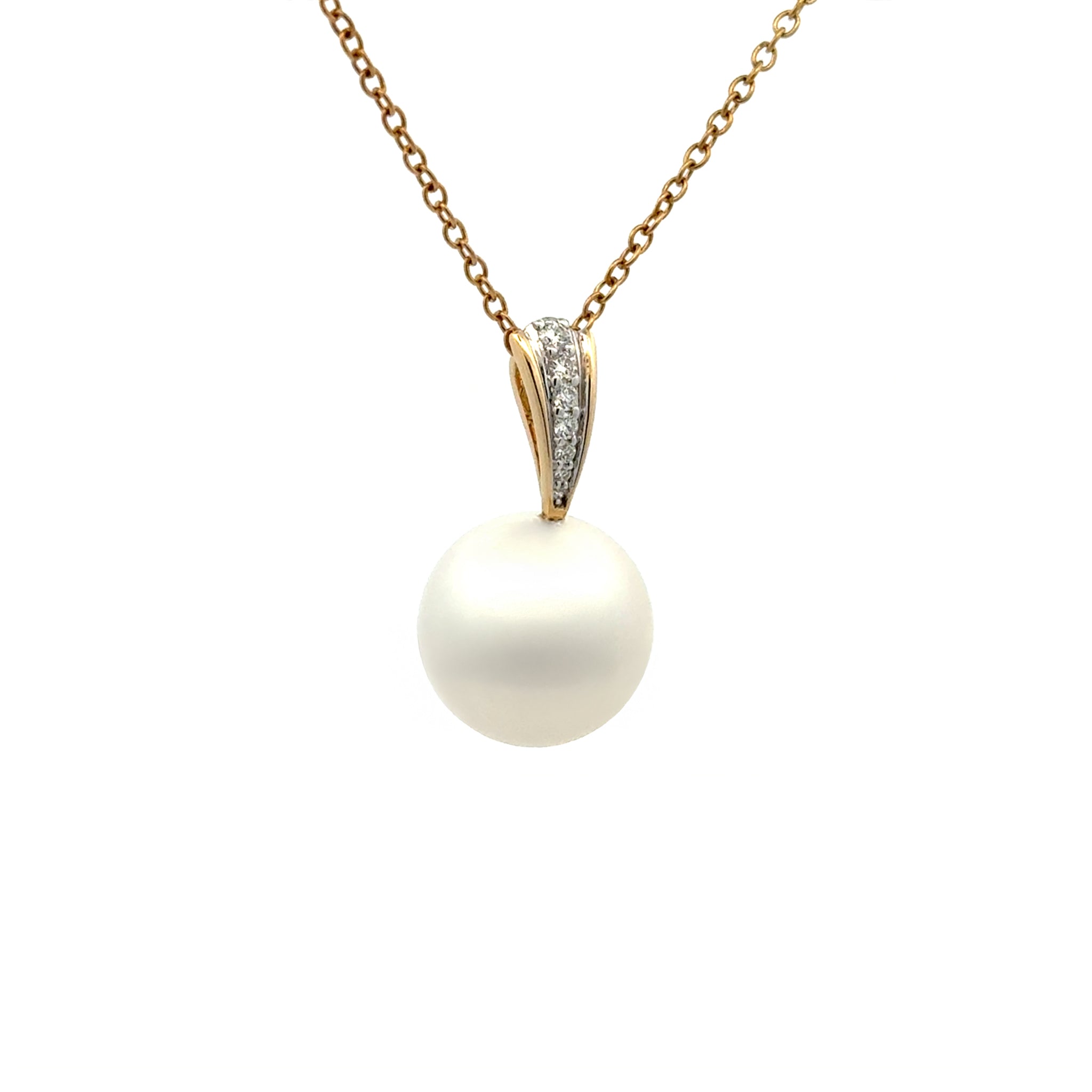 Pearl pendant necklace with yellow gold chain and diamond accents on a white background side view
