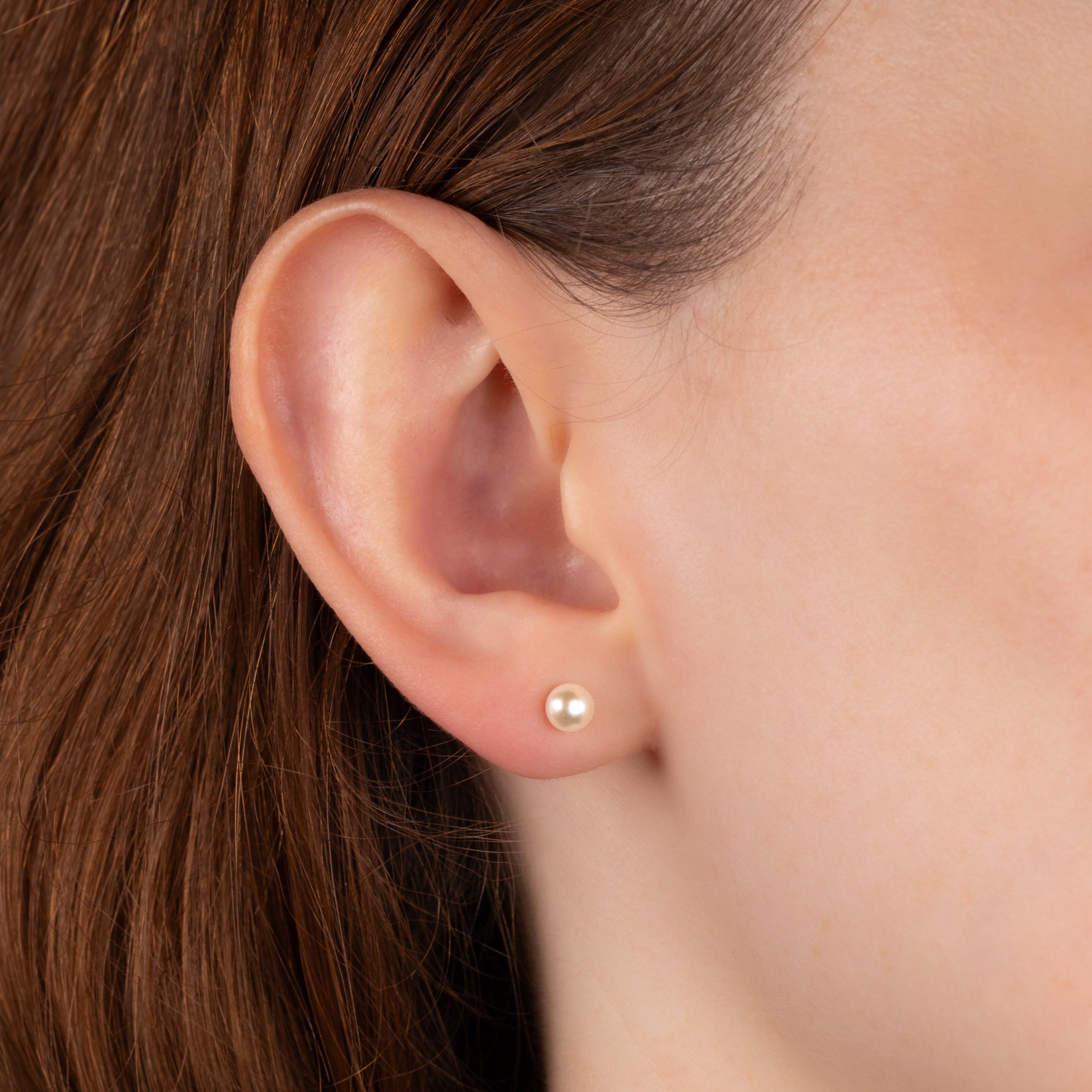 9K Yellow Gold Freshwater Pearl 4.5-5mm Stud Earrings worn on a model