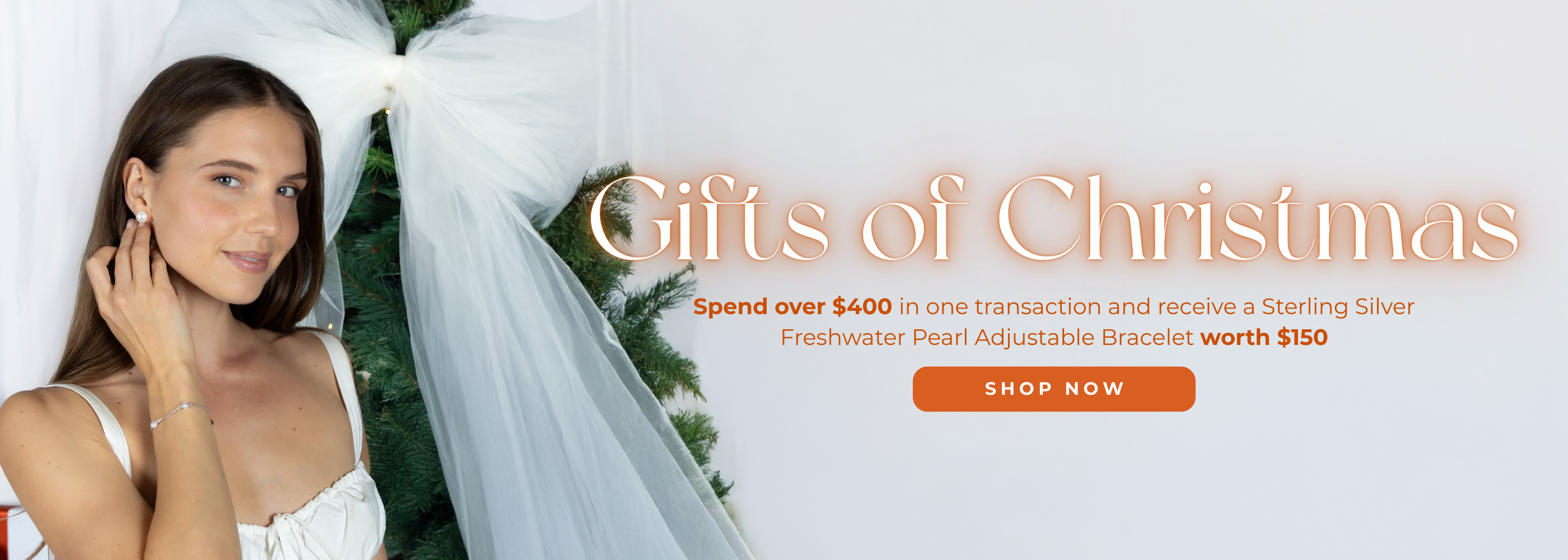 Woman wearing a white dress with a veil, surrounded by Christmas decorations, with a promotional message for a Sterling Silver Freshwater Pearl Adjustable Bracelet.