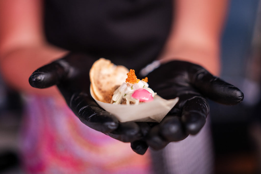 Hand wearing a black glove holding a sample of pearl meat