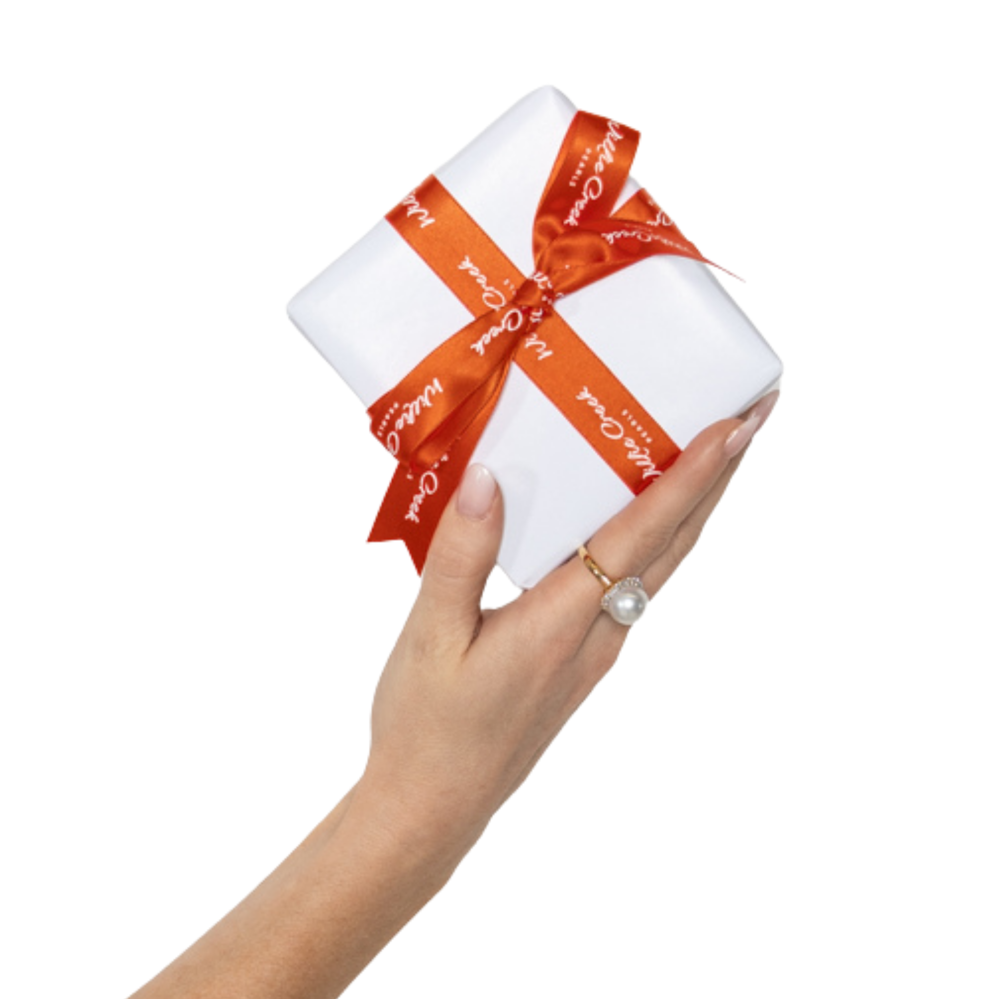 Willie Creek Pearls white gift wrap with a branded pindan bow, being held by a had wearing an australian south sea ring