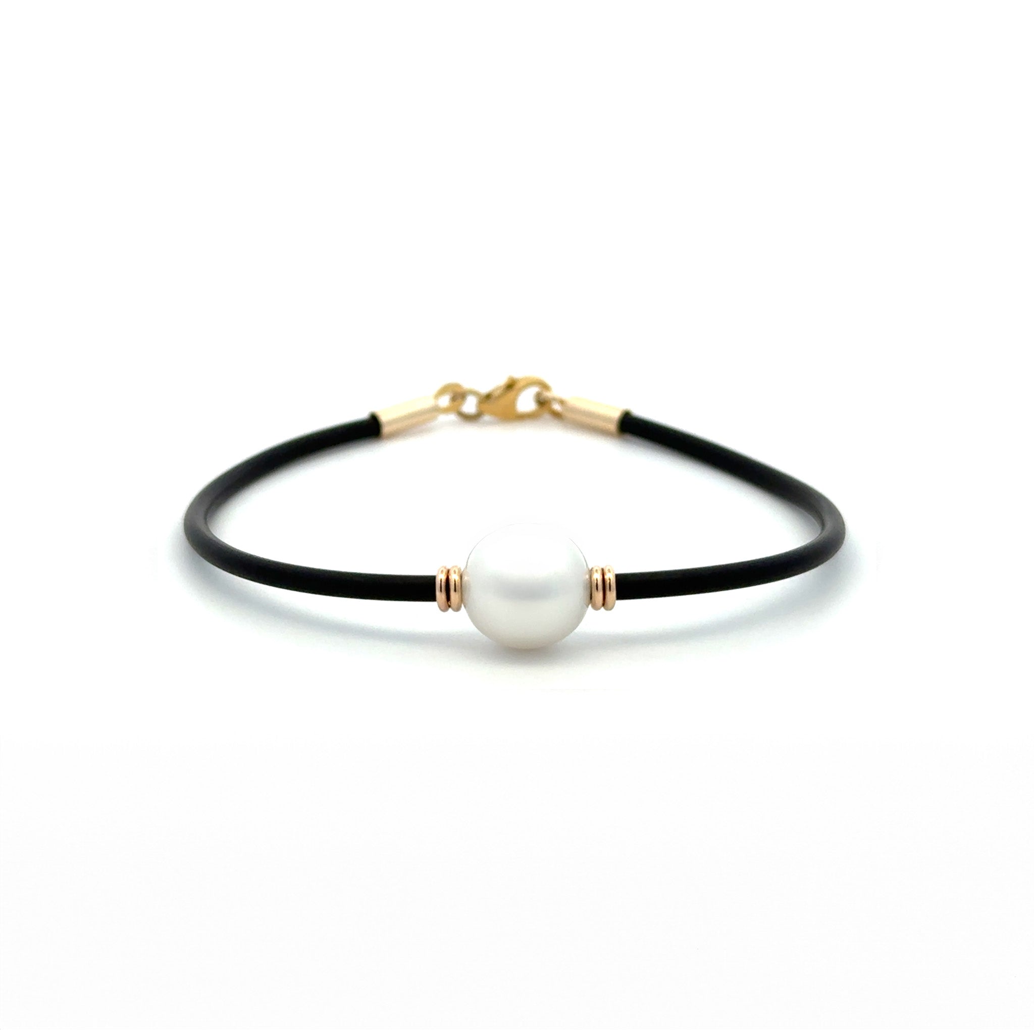 Black Neoprene Pearl Bracelet with 9k yellow gold clasp, with an Australian South Sea Peal cupped wither side by two yellow gold like beads on a white background