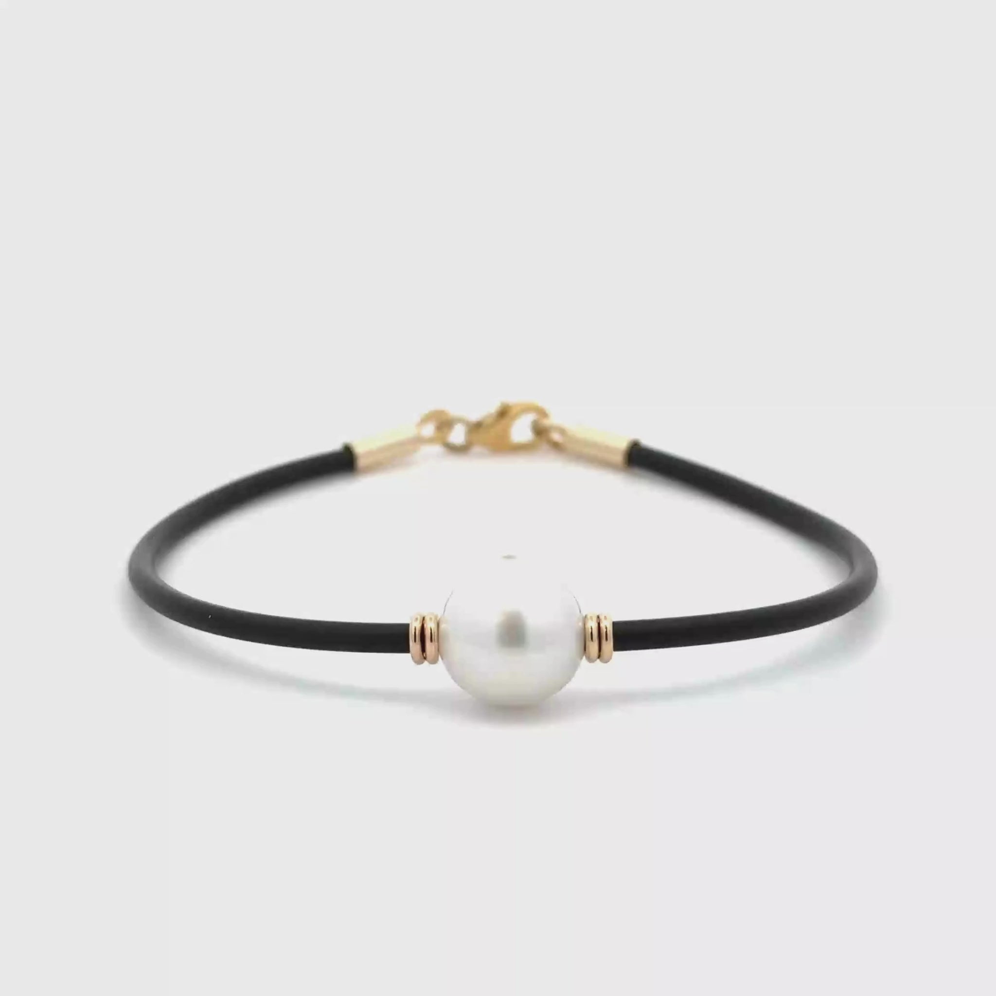 360 degree view of our black Neoprene Pearl Bracelet with 9k yellow gold clasp, with an Australian South Sea Peal cupped wither side by two yellow gold like beads on a white background