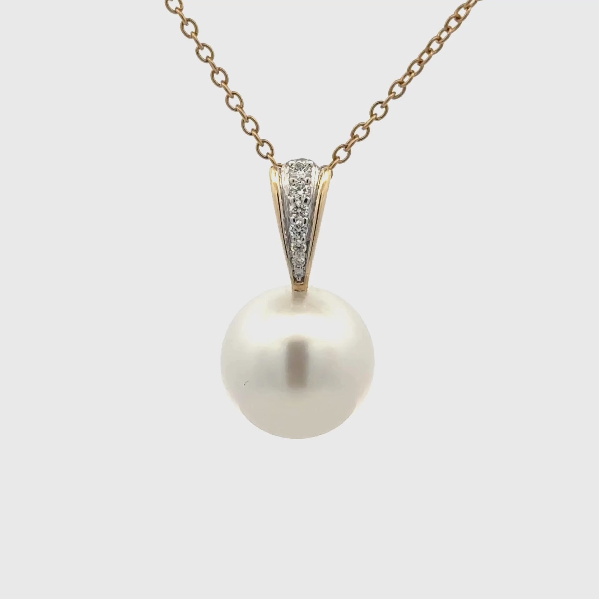 Pearl pendant necklace with yellow gold chain and diamond accents on a white background 360 degree view